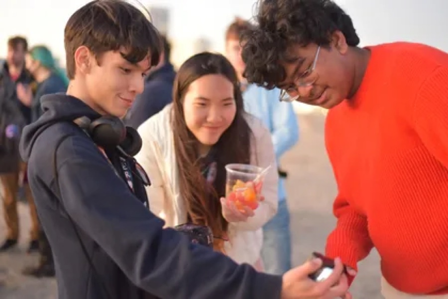 Three Hack Clubbers looking at a phone together
